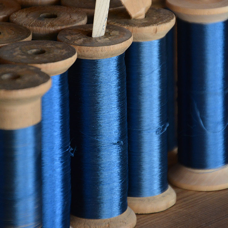 Illustration image of blue threads on spools